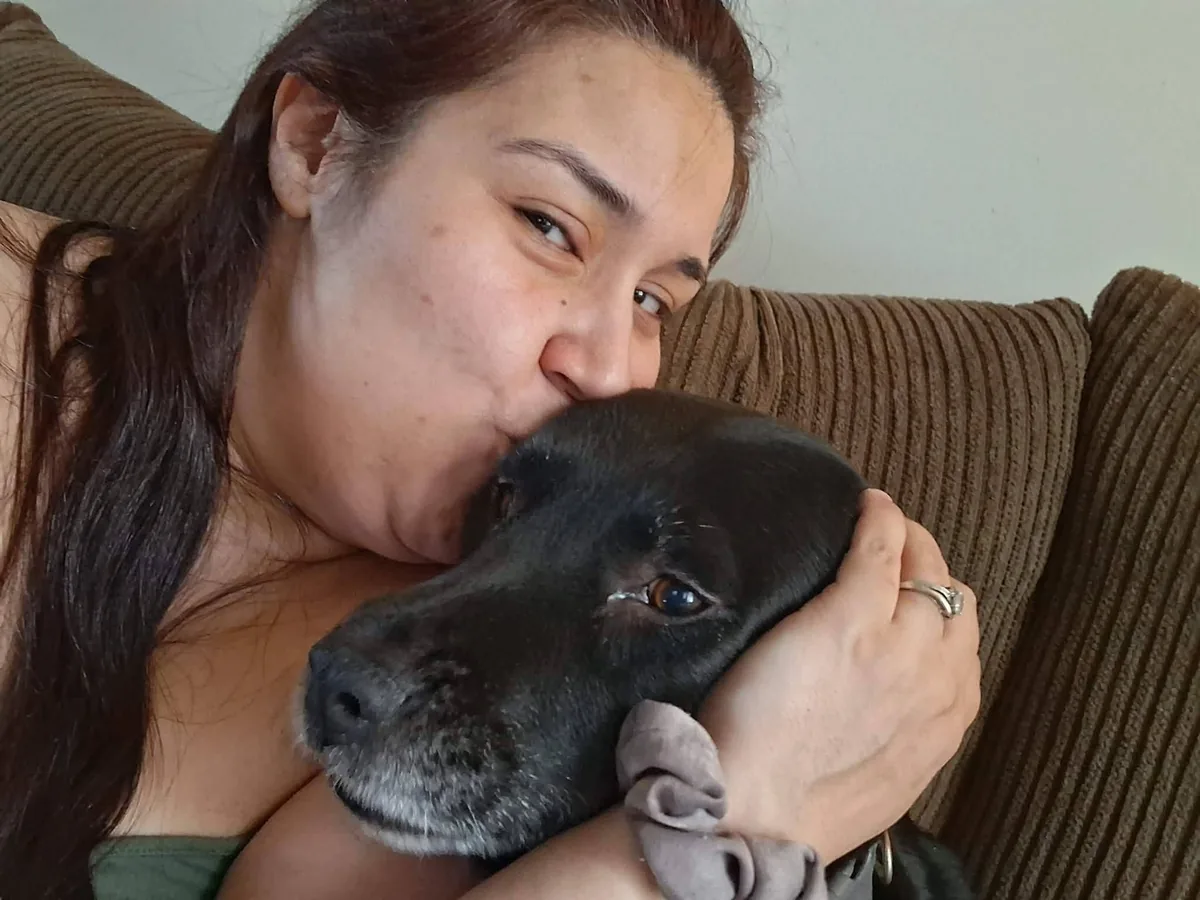 Karina warmly holding and caring for a dog